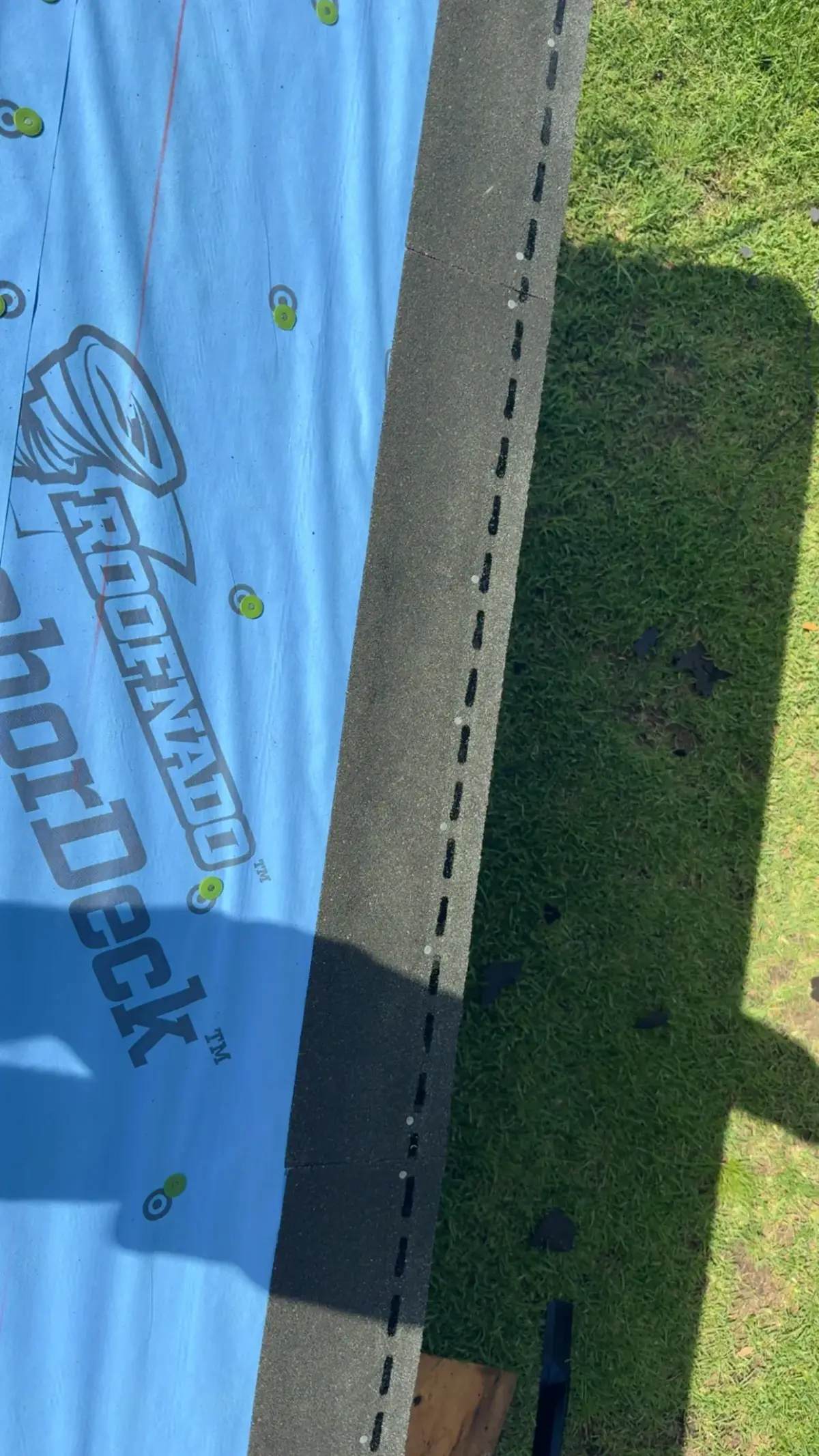 Synthetic underlayment and starter course installed at a roof edge — install detail