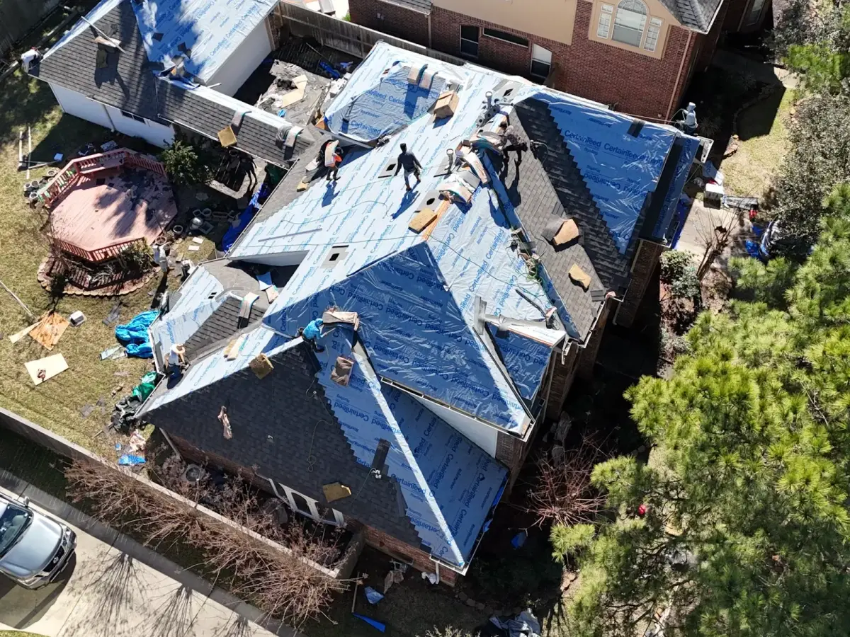 Northvale Roofing crew installing synthetic underlayment during this roof replacement — drone view